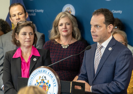 A photo of Councilmember Glass speaking at the press conference after the resolution was passed