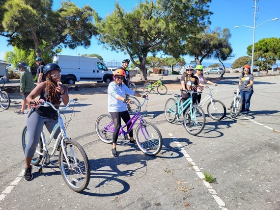 A photo of five adults with their bikes