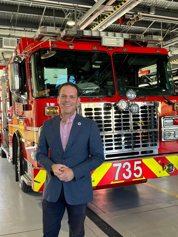 Councilmember Glass in front of one of the firetrucks at the Clarksburg Fire Station