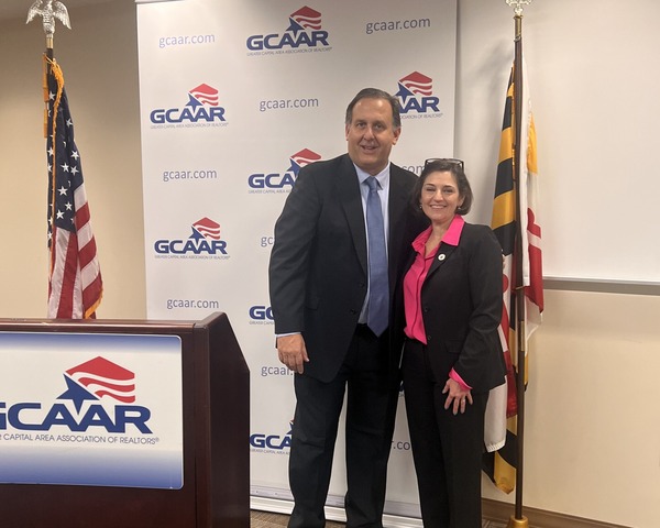 Council President Stewart and GCAAR president in front of a GCAAR backdrop with American and Maryland flags.