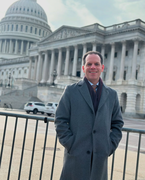 A picture of Councilmember Glass in front of the Supreme Court and U.S. Capitol buildings