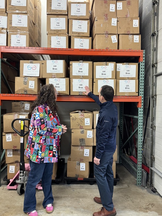 Councilmember Glass and Dana Marlowe look at boxes of clothing and menstrual products that have been donated