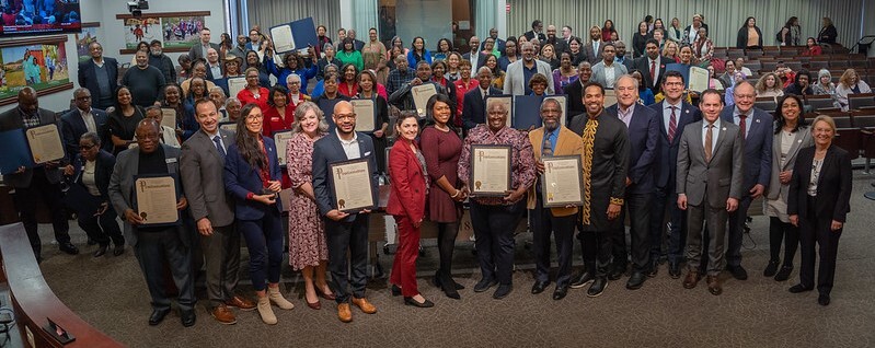 Large group photo in the Council chamber during Black History Month commemoration.