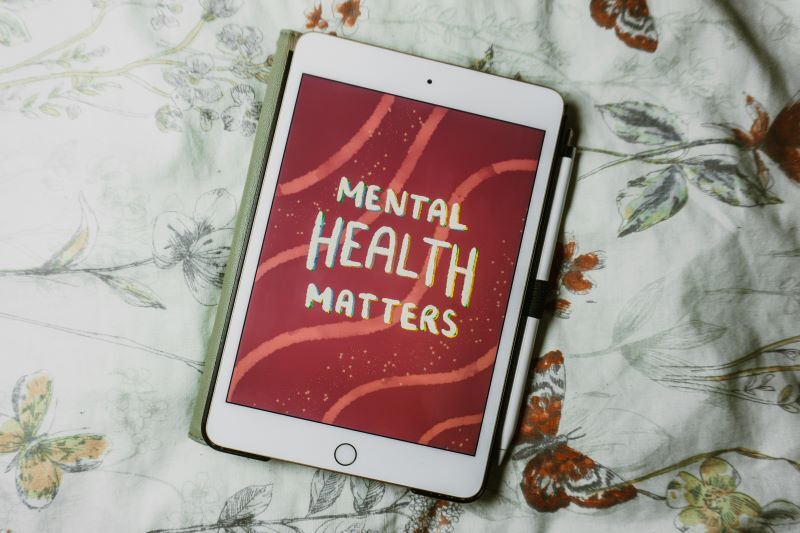 White iPad with red and white graphic reading “Mental Health Matters”.