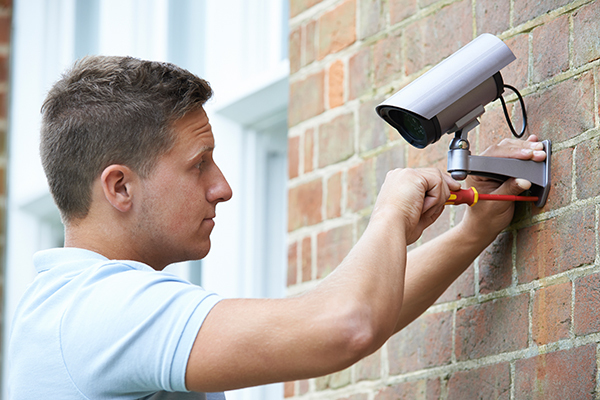 A man installing a security camera