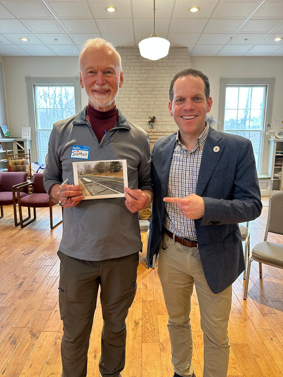 Councilmember Glass with a resident. The resident holds a photo of a road that was made safer after CM Glass contacted MCDOT.