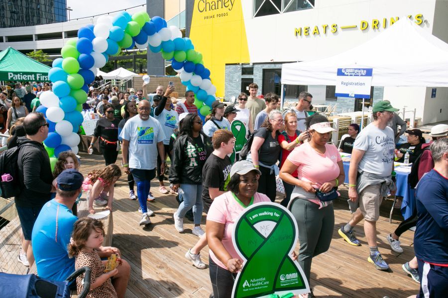 Crowd of participants at NAMIWalks Montgomery County with balloon arch in the background.