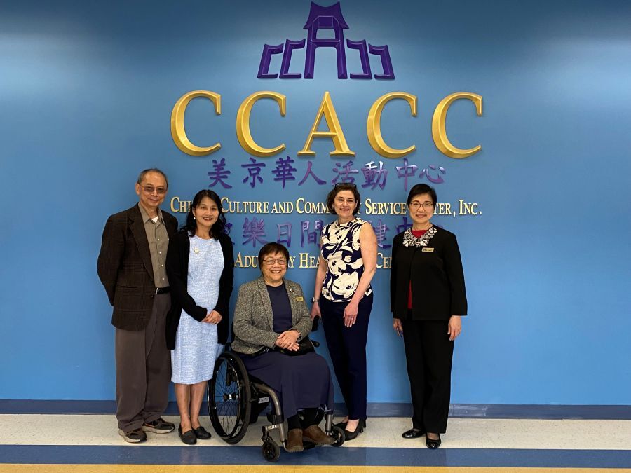 CP Stewart and CCACC leaders stand in front of a blue wall and gold CCACC logo with Chinese lettering.