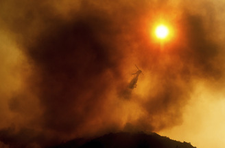A helicopter drops water on the River Fire in Salinas, California, in 2021. 