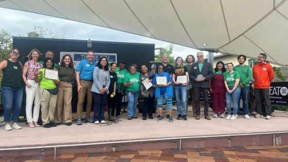 Group photo with GreenFest Eco Heroes and Planning Committee. 20 people standing on a stage.