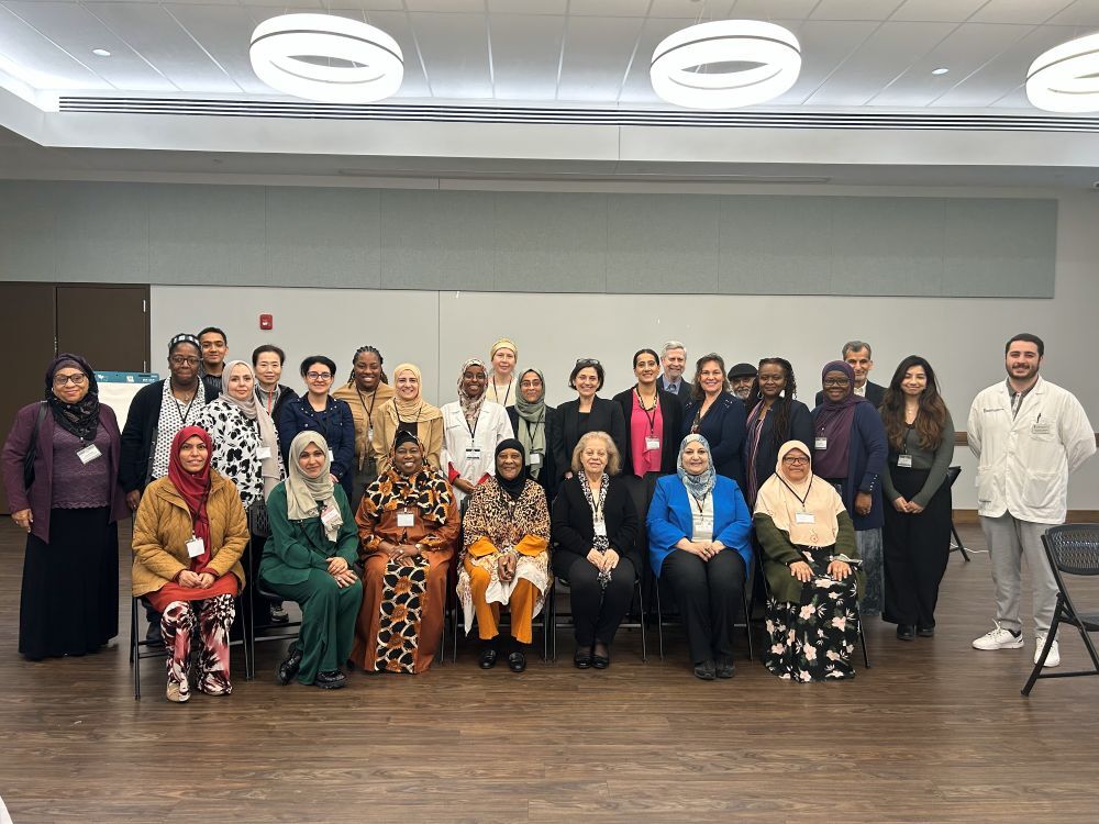 Council President Stewart smiles with a large group of healthcare providers at the American Muslim Senior Society.