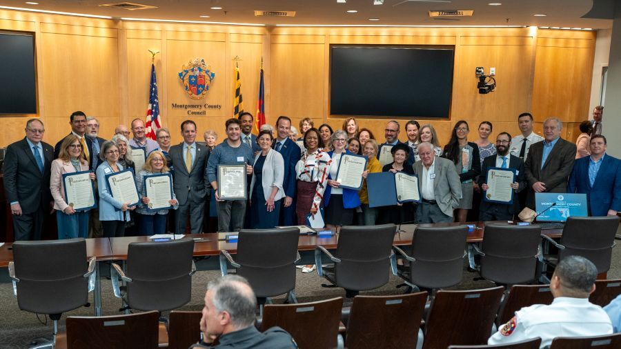 Councilmembers and community members gather with proclamations in the Council chamber for Jewish American Heritage Month.
