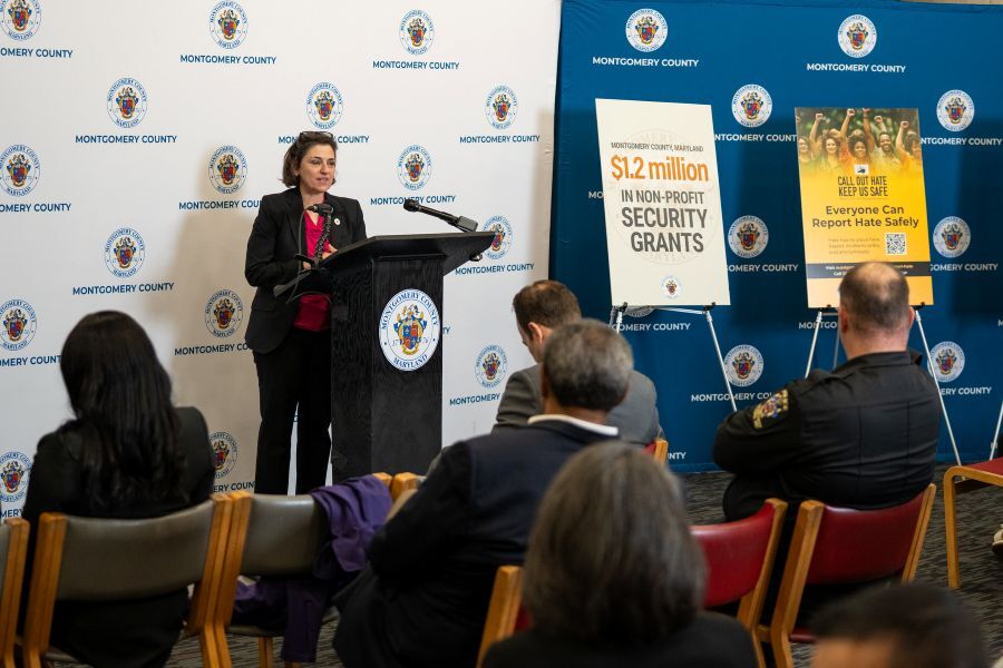 Council President Stewart speaks at a podium during a press conference announcing nonprofit security grants.