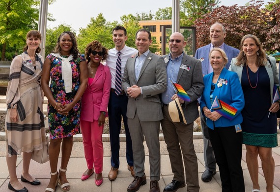 State and local elected officials join Councilmember Glass in holding Pride flags