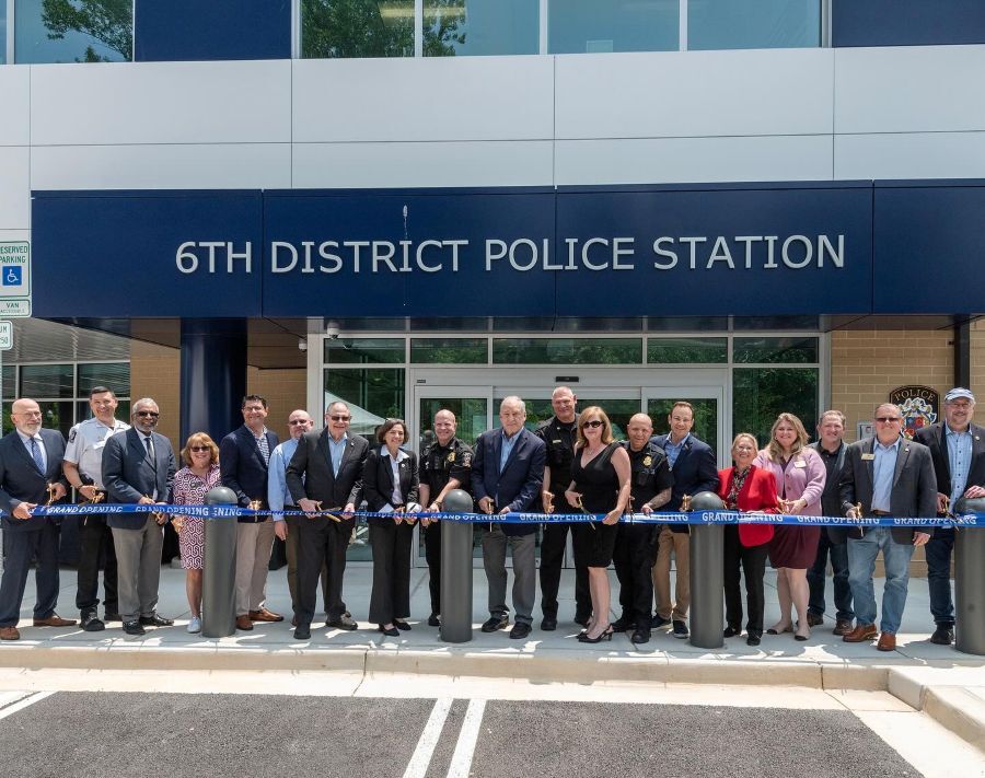 County leaders and public safety officials cut a blue ribbon in front of the new 6th District Police Station.