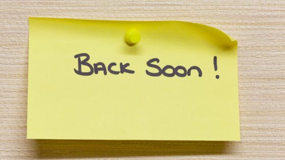 Sticky note pinned to a board with the words "back soon" written on the sticky note.