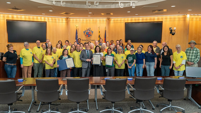 Councilmember Glass presents a proclamation to the Weed Warrior volunteers with Parks Director Miti Figueredo
