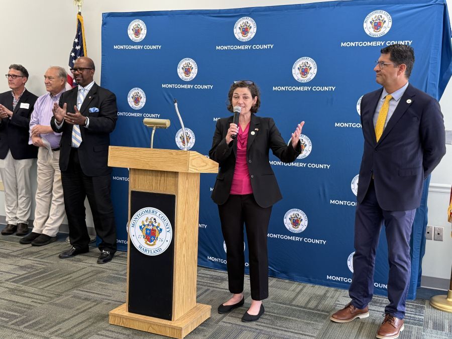 Council President Stewart speaks at a podium at the DHHS 30th anniversary event.