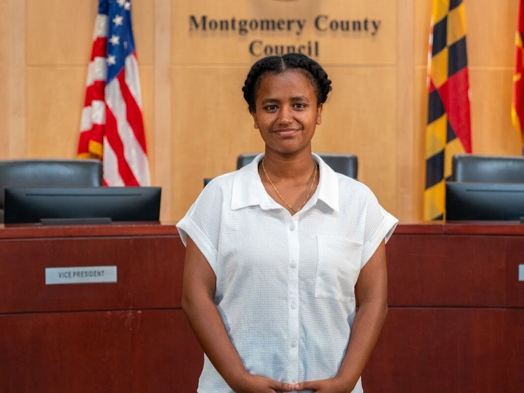 Headshot of Meron Aga in Council hearing room.