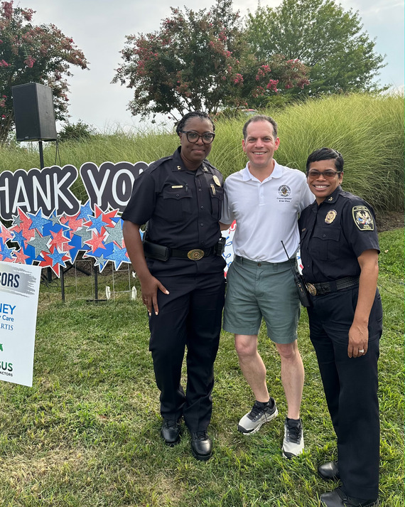 Councilmember Glass stands in between two MCPD officers