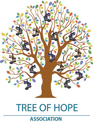 A tree with colorful leaves and shoes hanging off the branches. Text: Tree of Hope Association.