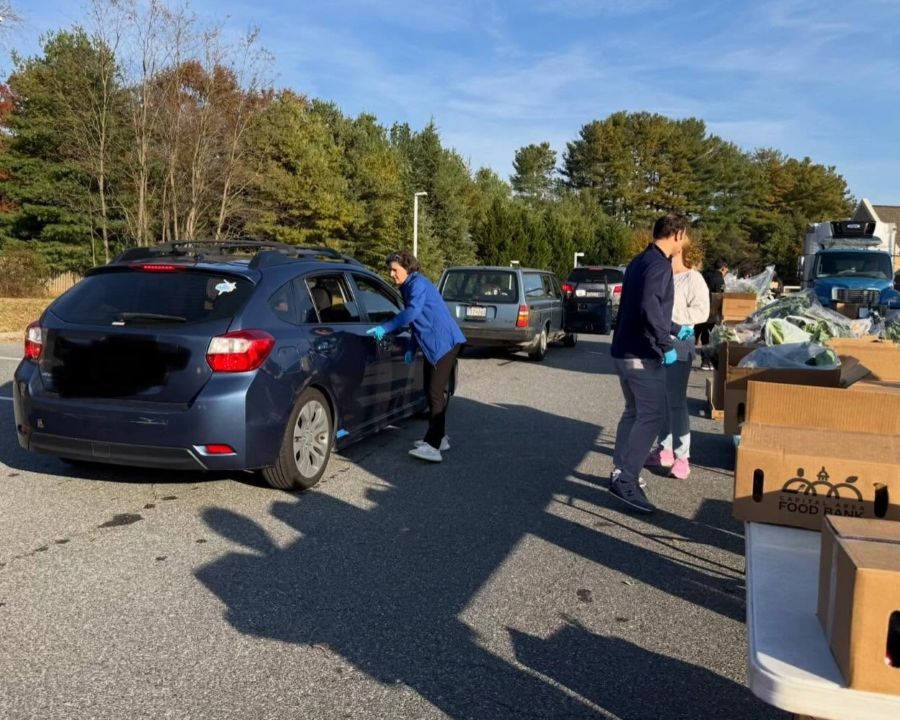 Council President Stewart speaks to someone in a car at a food distribution event.