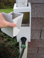 Image showing a person removing the inline downspout leaf and debris filter to clean it.