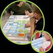 Participants playing a climate strategy board game with cards and scoring tiles.