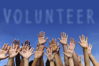 Volunteer graphic with many hands raised
