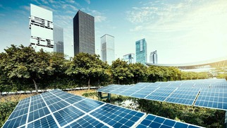 Solar panels installed in a green urban area with modern high-rise buildings in the background
