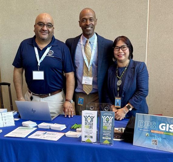dps outreach table with fliers and brochures and three staff members behind it