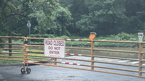 Road closed sign near a flooded road.
