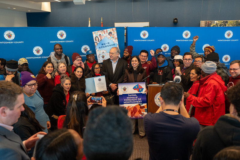 Fani-Gonzalez, Elrich, CASA and advocates at the Trust Act press conference. Fani-Gonzalez holds a sign “Juntos, somos el Condado de Montgomery.”