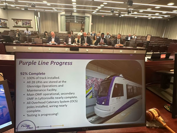 A picture of a presentation slide titled "Purple Line Progress" is shown during the Transportation & Environment Committee session.
