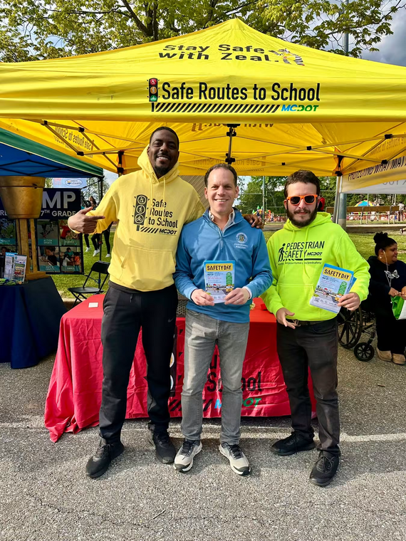 Councilmember Glass with two Safe Routes to Schools program ambassadors at an informational table about the program.
