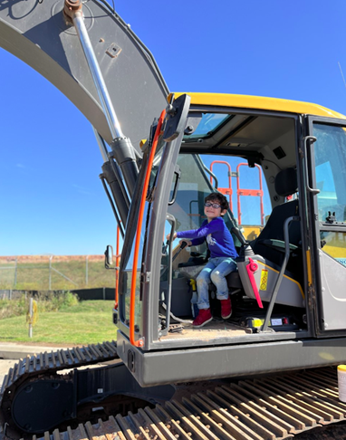 A young kid sitting in an excavator