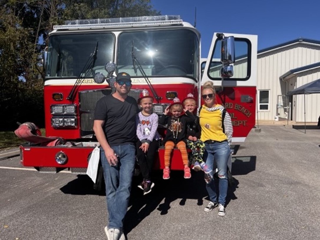 Open House attendees take a picture with the fire truck