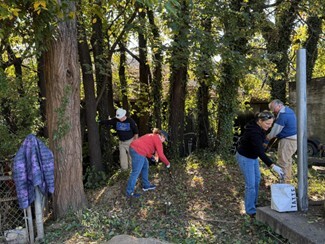Volunteers clearing an area for new outdoor storage.