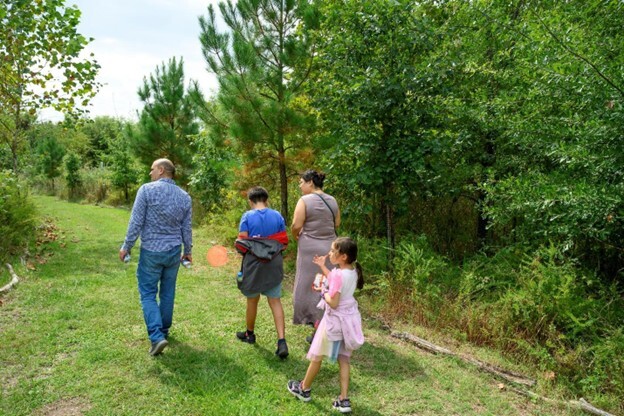 Family walking on a trail at Masonville Cove
