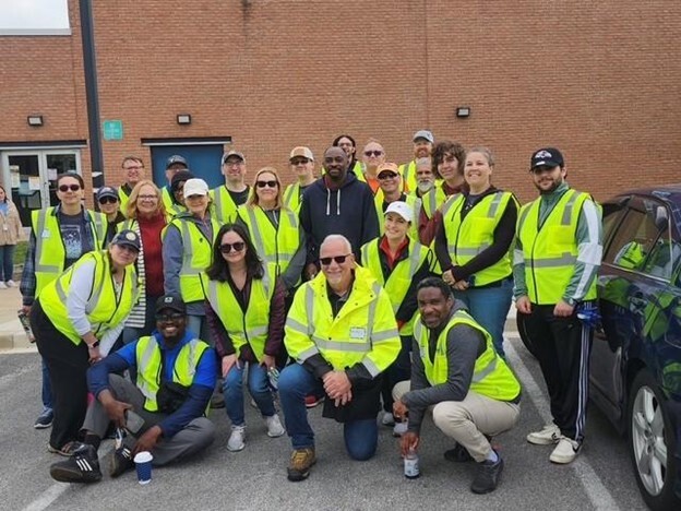Group image of volunteers at the Turner Station Earth Day event in green construction vests. 