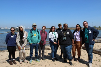 Group photo of attendees at a Nature Worx training session standing on the shore at Masonville Cove
