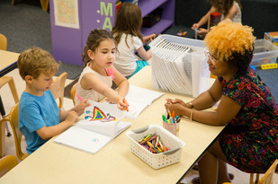 provider sitting with girl and boy coloring