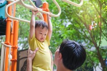 Asian dad and son on playground