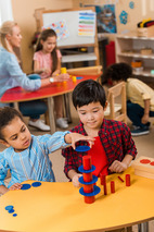 Young children playing and learning at table together in prekindergarten classroom setting.