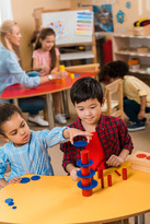 Fotografía de niños pequeños jugando y aprendiendo juntos en un aula de preescolar.