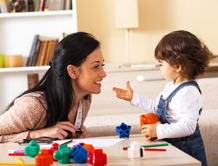 Mother and child playing with toys together at home.