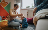 Parent and baby playing together in family support center facility.