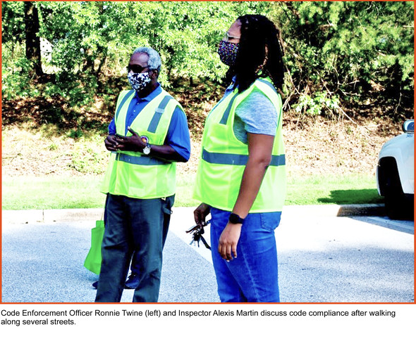 Code Enforcement Officer Ronnie Twine (left) and Inspector Alexis Martin discuss code compliance after walking along several streets.