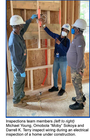 Inspections team members (left to right) Michael Young, Omobola “Moby” Sokoya and Darrell K. Terry inspect wiring during an electrical inspection