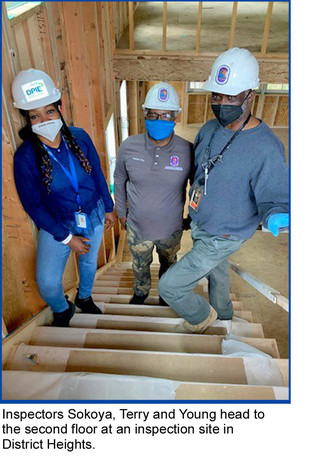 3 inspectors climbing stairs. Inspectors Sokoya, Terry and Young head to the second floor at an inspection site in District Heights.